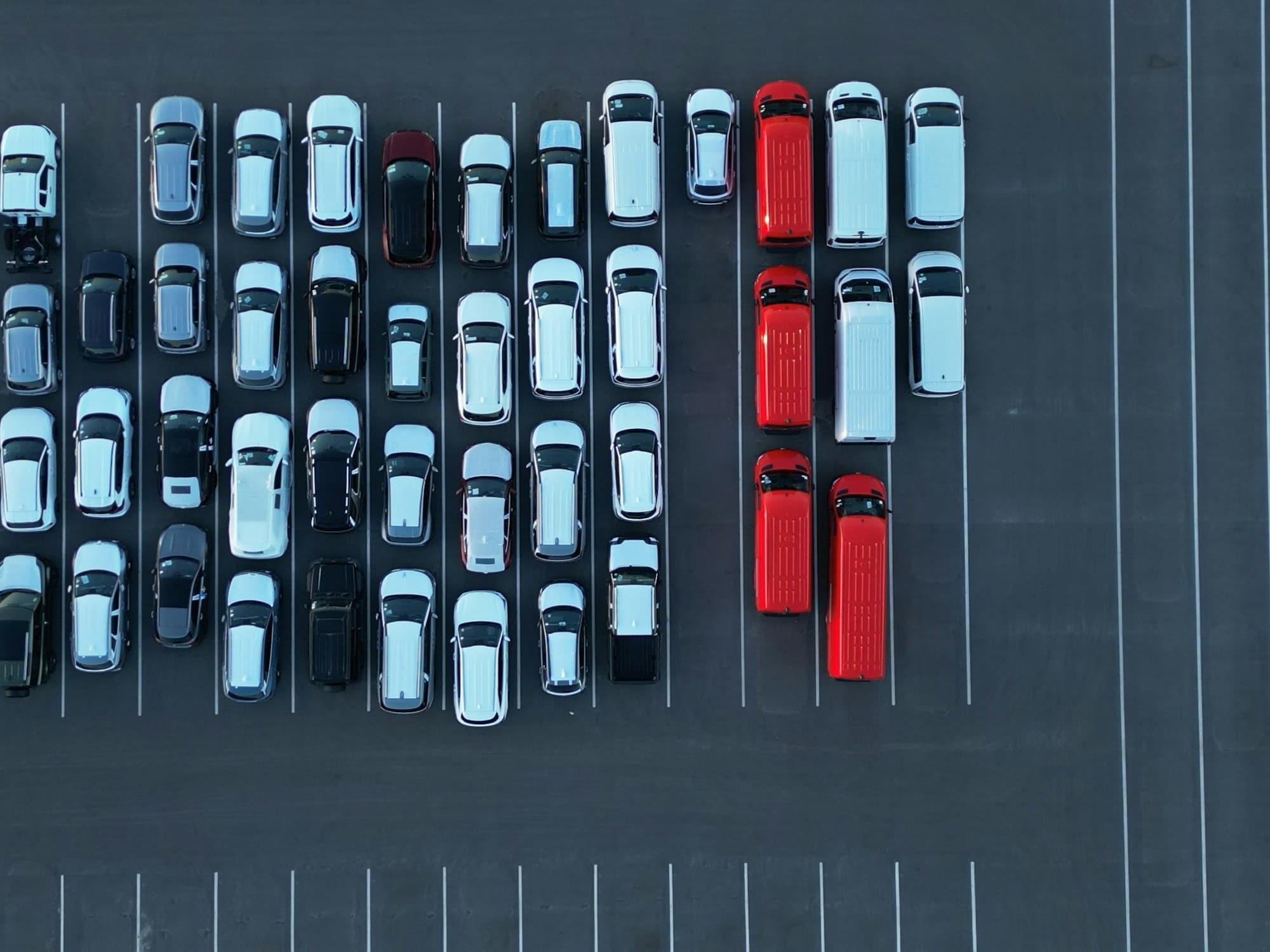 Luchtfoto van een wagenpark met geparkeerde auto's en bestelwagens